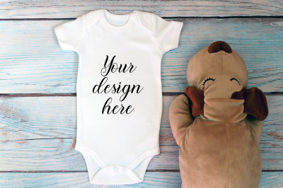 Baby Bodysuit mockup with toy on a wooden background.