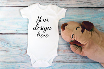 Baby Bodysuit mockup with toy on a wooden background.