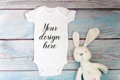 Baby Bodysuit mockup with toy on a wooden background.