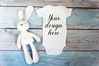 Baby Bodysuit mockup with toy on a wooden background.