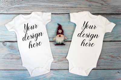 Two Christmas baby bodysuits Mockup on a wooden background.