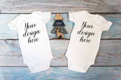 Two Christmas baby bodysuits Mockup on a wooden background.