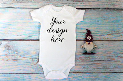 Christmas Baby bodysuit mockup on a wooden background.