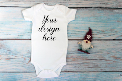 Christmas Baby bodysuit mockup on a wooden background.