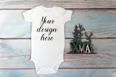 Christmas Baby bodysuit mockup on a wooden background.