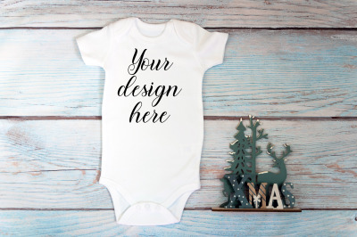 Christmas Baby bodysuit mockup on a wooden background.