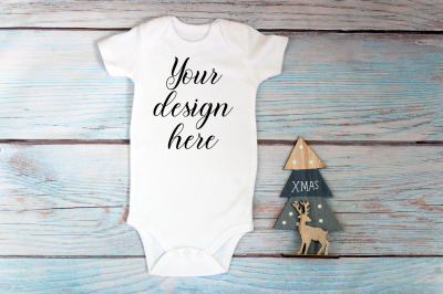 Christmas Baby bodysuit mockup on a wooden background.