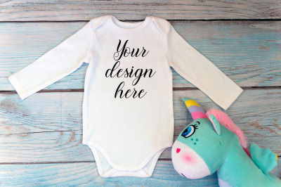 Bodysuit Mockup with long sleeves and unicorn toy on a wooden backgrou