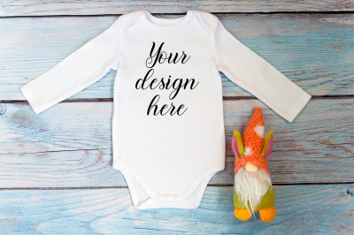 Baby Bodysuit Mockup with gnome toy on a wooden background.