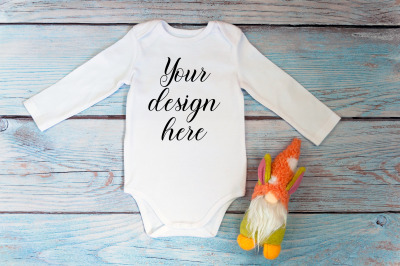 Baby Bodysuit Mockup with gnome toy on a wooden background.