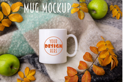 White coffee mug mockup with woolen blanket, apples and fall leaves.