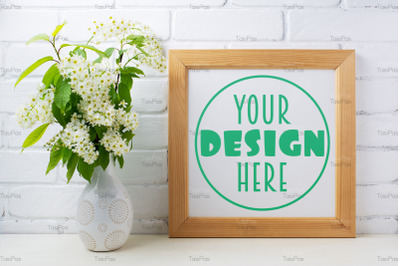Square wooden picture frame mockup with bird cherry bouquet.
