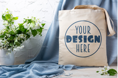 Rustic tote bag mockup with apple blossom in the vase.