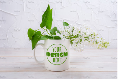 White coffee mug mockup with tender white lilac branch.