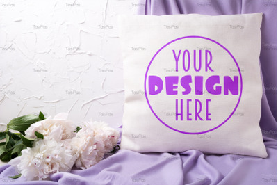 Pillow mockup with pink peony and lilac scarf.