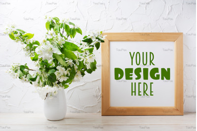 Square wooden picture frame mockup with tender apple blossom.
