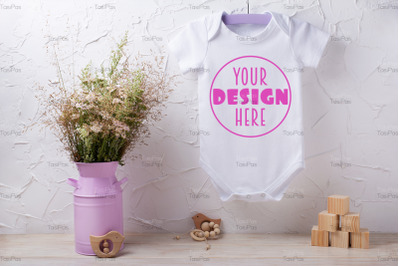 White baby short sleeve bodysuit mockup with wild flowers and wooden c