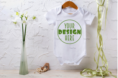 White baby short sleeve bodysuit mockup with lily and green ribbon.