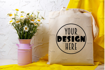 Rustic tote bag mockup with wild daisy flowers in the pink can.