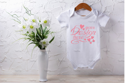 White baby short sleeve bodysuit mockup with lily bouquet.