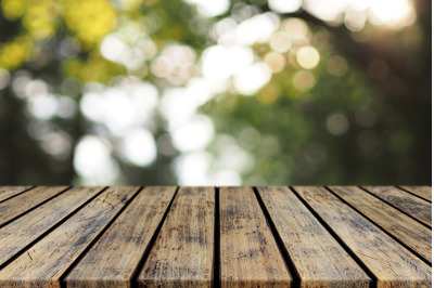 Empty Rustic Plank Wood Table top with Blurred Tree Bokeh Background