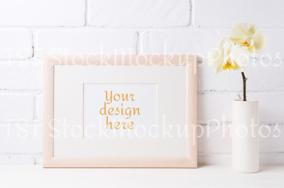 Wooden landscape frame mockup with soft yellow orchid in vase