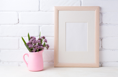 Wooden frame mockup with purple flowers in pink pitcher 