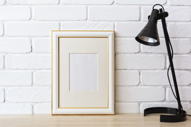 gold-decorated-frame-mockup-with-black-table-lamp