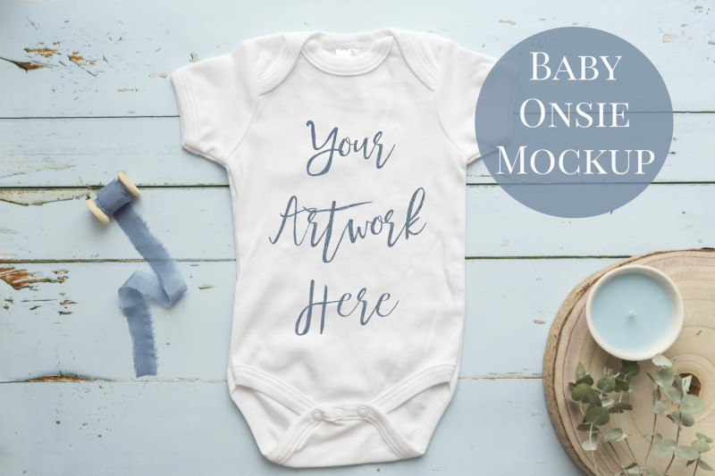 babygrow-romper-suit-onsie-mockup-with-blue-wooden-background