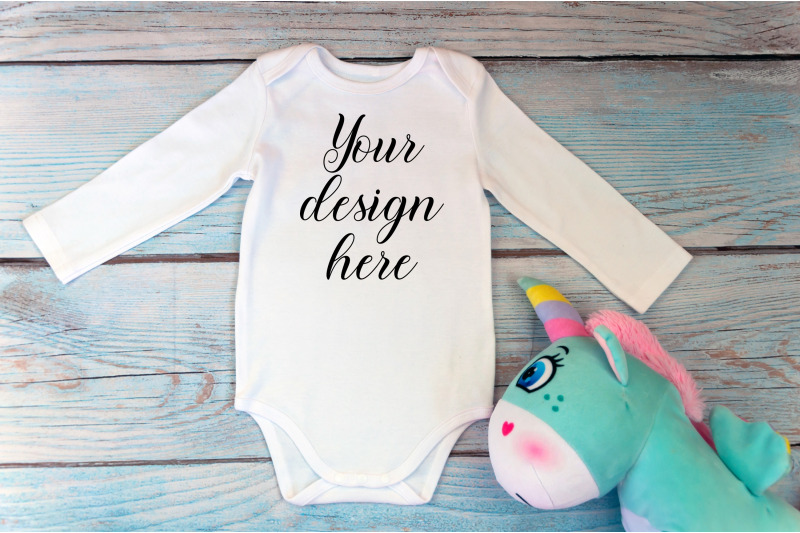 bodysuit-mockup-with-long-sleeves-and-unicorn-toy-on-a-wooden-backgrou