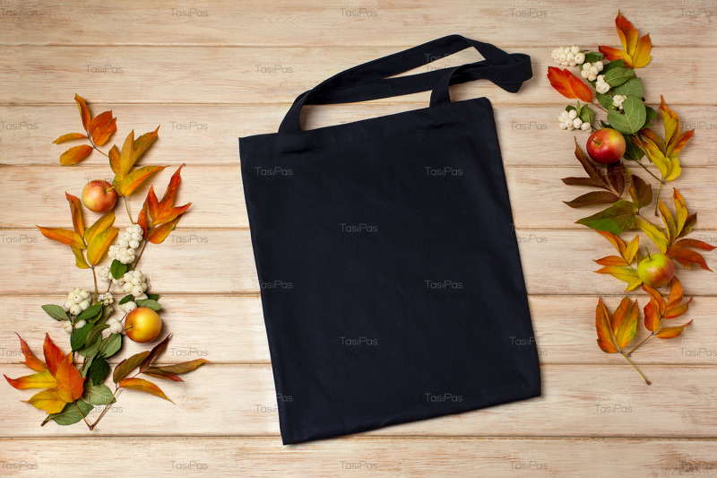 black-tote-bag-mockup-with-fall-leaves-and-snowberry