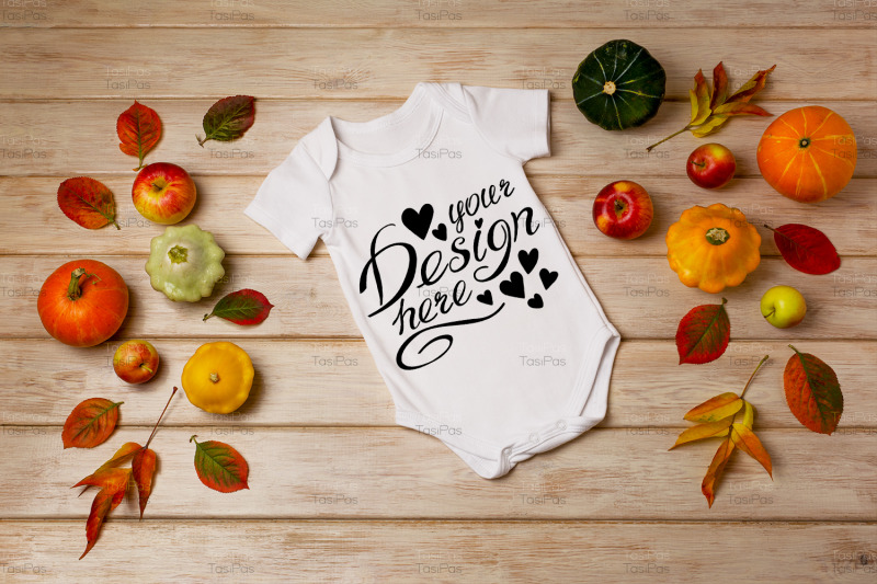 white-baby-short-sleeve-bodysuit-mockup-with-fall-decor