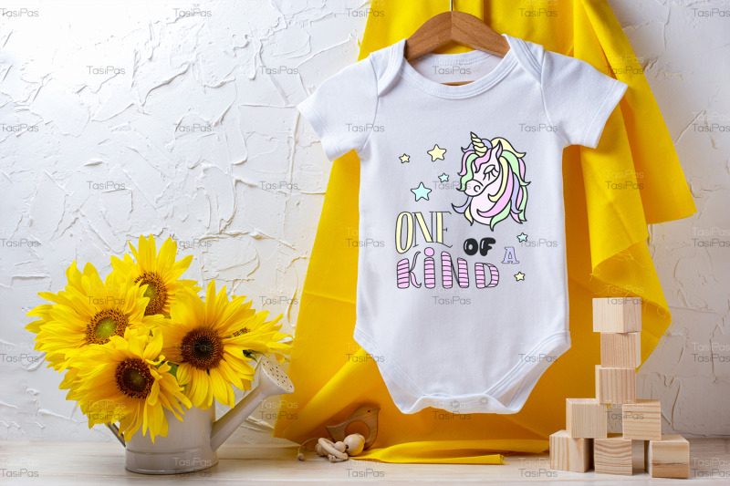 white-baby-short-sleeve-bodysuit-mockup-with-sunflowers-and-wooden-toy