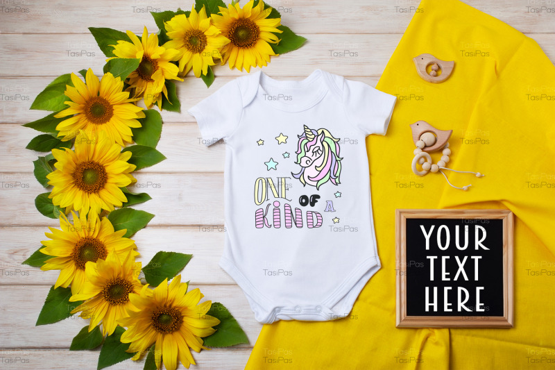 white-baby-short-sleeve-bodysuit-mockup-with-sunflowers-and-black-chal