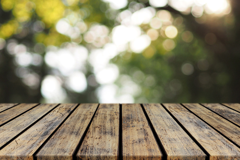 empty-rustic-plank-wood-table-top-with-blurred-tree-bokeh-background