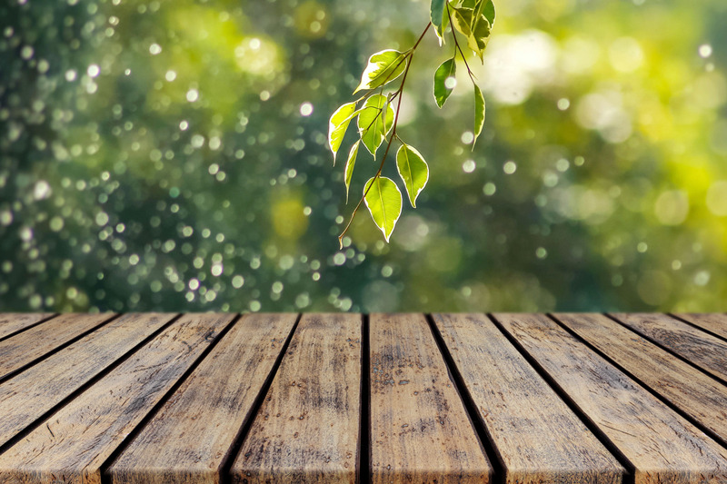empty-wooden-deck-table-old-rustic-plank-with-leaves-bokeh-background