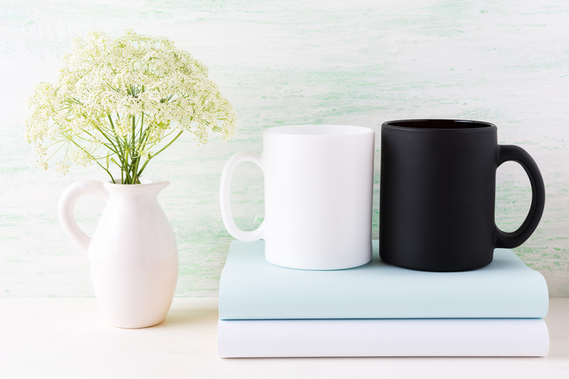 white-and-black-mug-mockup-with-books-and-white-flowers