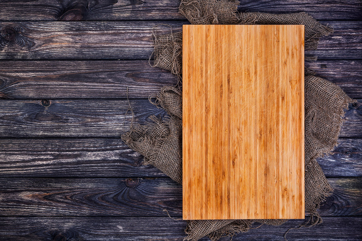 Cutting board on dark wood background, top view By Xamtiw | TheHungryJPEG